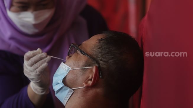 Calon penumpang melakukan tes usap antigen sebelum menaiki bus di Terminal Kampung Rambutan, Jakarta, Selasa (21/12/2021). [Suara.com/Angga Budhiyanto]