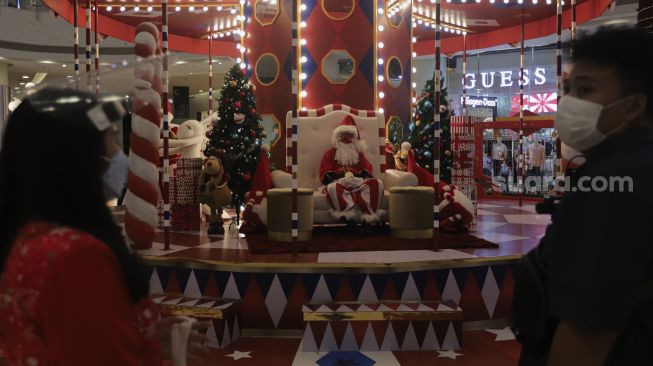 Santa Claus duduk di area dekorasi Natal di Central Park Mall, Jakarta, Selasa (21/12/2021). [Suara.com/Angga Budhiyanto]