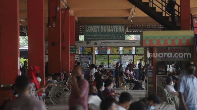 Sejumlah calon penumpang menunggu kedatangan bus di Terminal Kampung Rambutan, Jakarta, Selasa (21/12/2021). [Suara.com/Angga Budhiyanto]