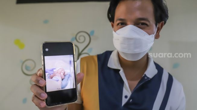 Suami Fairuz A Rafiq, Sonny Septian menunjukkan foto anak ketiga mereka King Zhafi Zayyan Slofa yang baru saja lahir di RSIA Bunda, Menteng, Jakarta Pusat, Rabu (22/12/2021). [Suara.com/Alfian Winanto]