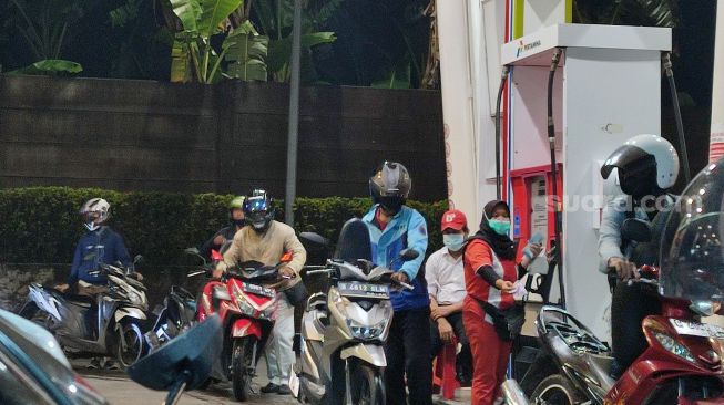 Aktivitas pengisian BBM di SPBU Bintaro di Jalan Utama Sektor 3 Pondok Betung, Kecamatan Pondok Aren, Kota Tangerang Selatan (Tangsel), Selasa (21/12/2021) malam. [SuaraJakarta.id/Wivy Hikmatullah]