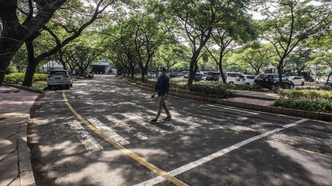 Warga berjalan di lokasi yang akan dijadikan Jakarta International E-Prix Circuit (JIEC) di kawasan Taman Impian Jaya Ancol, Jakarta, Rabu (22/12/2021). ANTARA FOTO/Aprillio Akbar