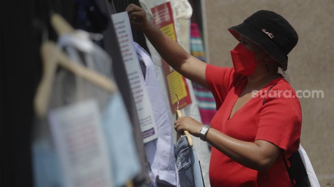 Massa yang tergabung dalam Jaringan Pembela Hak Perempuan Korban Kekerasan Seksual memasang instalasi pakaian korban kekerasan seksual saat melakukan aksi unjuk rasa di depan Gedung DPR, Jakarta, Rabu (22/12/2021). [Suara.com/Angga Budhiyanto]