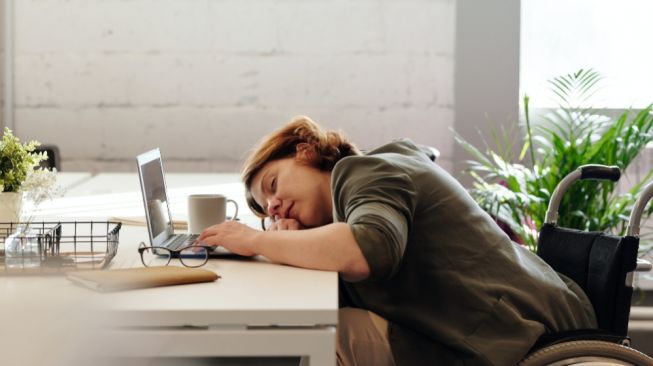 Ilustrasi seorang wanita tidur di tempat kerja (Pexels/Marcus Aurelius)