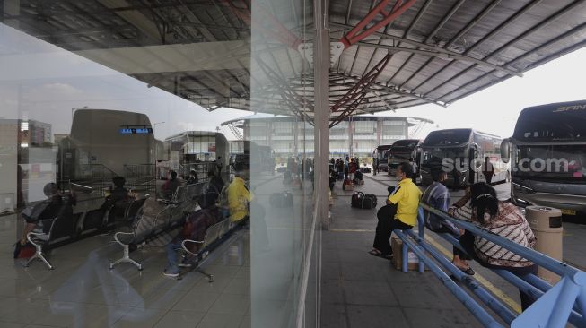 Calon penumpang menunggu kedatangan bus AKAP di Terminal Terpadu Pulo Gebang, Jakarta, Kamis (23/12/2021). [Suara.com/Angga Budhiyanto]