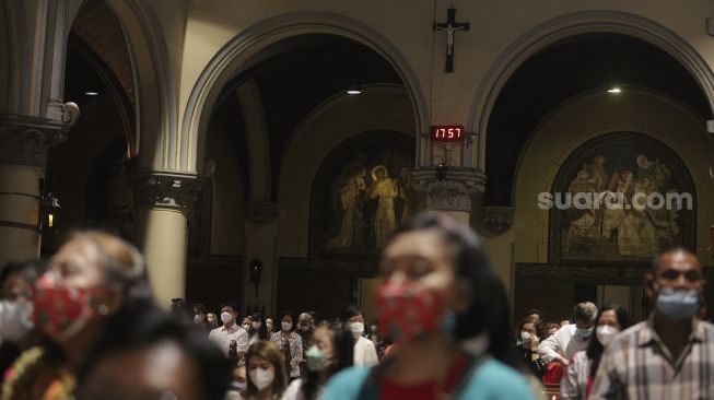 Umat Kristiani mengikuti Misa Natal di Gereja Katedral, Jakarta, Jumat (24/12/2021). [Suara.com/Angga Budhiyanto]