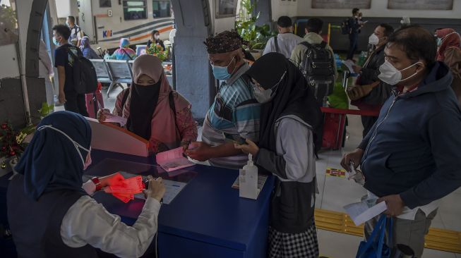 Penumpang antre untuk memasuki area peron di Stasiun Pasar Senen, Jakarta, Jumat (24/12/2021).  ANTARA FOTO/Galih Pradipta
