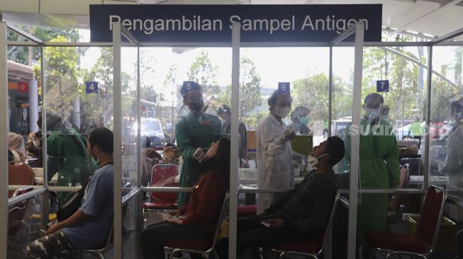 Petugas kesehatan melakukan tes usap antigen kepada calon penumpang di Stasiun Pasar Senen, Jakarta, Jumat (24/12/2021). [Suara.com/Angga Budhiyanto]