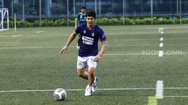 Aksi Aktor Iko Uwais bermain sepak bola saat laga persahabatan antara Selebritis FC vs AIFC Garuda Putih di Lapangan ABC Senayan, Jakarta Pusat, Jumat (24/12/2021). [Suara.com/Alfian Winanto]