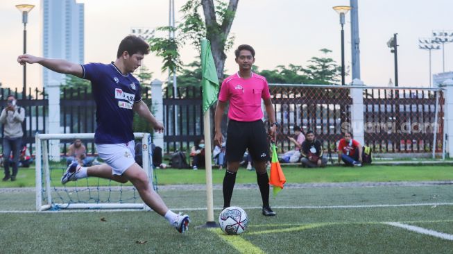 Aksi Aktor Iko Uwais bermain sepak bola saat laga persahabatan antara Selebritis FC vs AIFC Garuda Putih di Lapangan ABC Senayan, Jakarta Pusat, Jumat (24/12/2021). [Suara.com/Alfian Winanto]