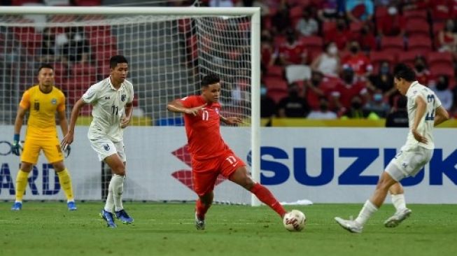 Pemain Singapura Irfan Fandi berduel dengan pemain Thailand dalam pertandingan Piala AFF 2020 di Stadion Nasional, 18 Desember 2021. [AFP]