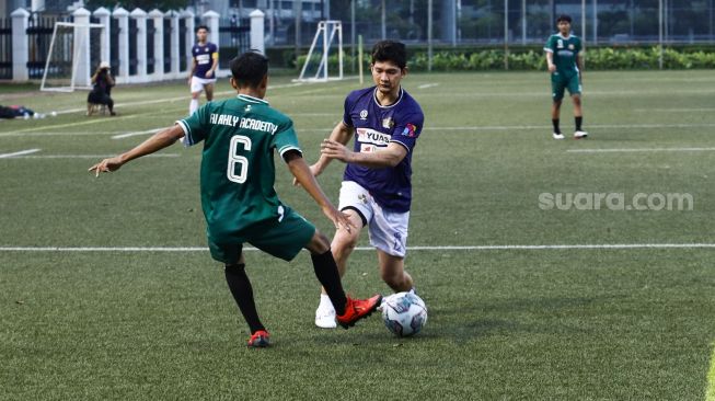 Aksi Aktor Iko Uwais bermain sepak bola saat laga persahabatan antara Selebritis FC vs AIFC Garuda Putih di Lapangan ABC Senayan, Jakarta Pusat, Jumat (24/12/2021). [Suara.com/Alfian Winanto]