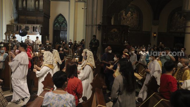 Umat Kristiani mengikuti Misa Natal di Gereja Katedral, Jakarta, Jumat (24/12/2021). [Suara.com/Angga Budhiyanto]