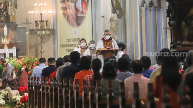 Umat Kristiani saat mengikuti Misa Natal di Gereja Katedral, Jakarta Pusat, Sabtu (25/12/2021). [Suara.com/Alfian Winanto,]