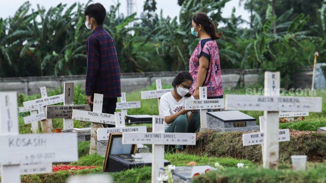 Warga ziarah di makam keluarganya di TPU Rorotan, Jakarta Utara, Sabtu (25/12/2021). [Suara.com/Alfian Winanto]