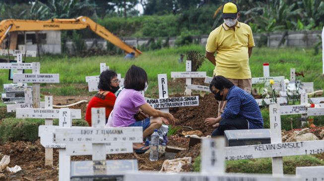 Warga ziarah di makam keluarganya di TPU Rorotan, Jakarta Utara, Sabtu (25/12/2021). [Suara.com/Alfian Winanto]