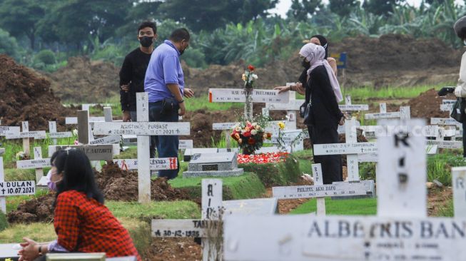 Warga ziarah di makam keluarganya di TPU Rorotan, Jakarta Utara, Sabtu (25/12/2021). [Suara.com/Alfian Winanto]