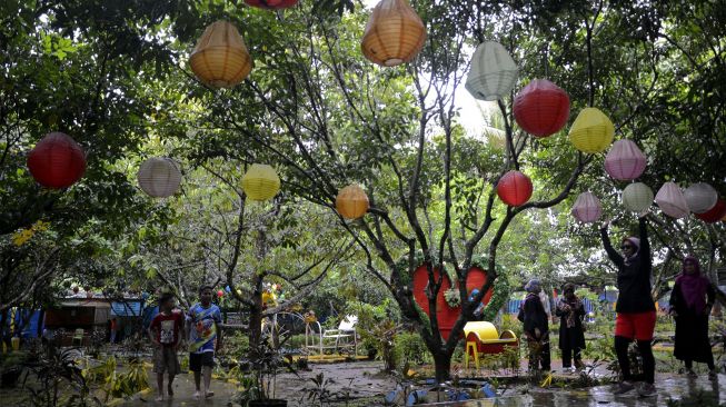 Wisatawan menikmati liburan di kawasan Wisata Kebun, Kabupaten Gowa, Sulawesi Selatan, Minggu (26/12/2021). [ANTARA FOTO/Abriawan Abhe]