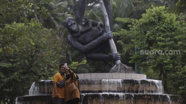 Pengunjung berswafoto di Taman Margasatwa Ragunan, Jakarta, Minggu (26/12/2021). [Suara.com/Angga Budhiyanto]