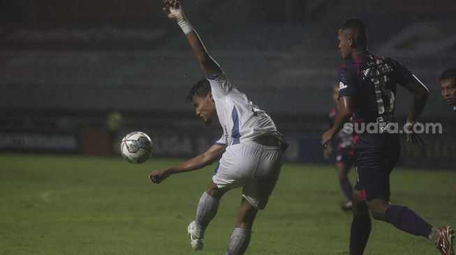 Pemain belakang PSIM Yogyakarta Aditya Putra Dewa (kiri) melepaskan umpan dalam pertandingan semifinal Liga 2 antara RANS Cilegon FC melawan PSIM Yogyakarta di Stadion Pakansari, Bogor, Jawa Barat, Senin (27/12/2021). [Suara.com/Angga Budhiyanto]