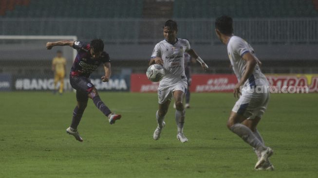 Pemain belakang RANS Cilegon FC Kurniawan (kiri) melepaskan tembakan dalam pertandingan semifinal Liga 2 antara RANS Cilegon FC melawan PSIM Yogyakarta di Stadion Pakansari, Bogor, Jawa Barat, Senin (27/12/2021). [Suara.com/Angga Budhiyanto]