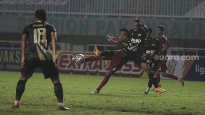 Pemain belakang Martapura Dewa United Hery Susilo (ketiga kiri) menghadang percobaan tembakan dari penyerang Persis Solo Alberto Goncalves dalam pertandingan semifinal Liga 2 antara Martapura Dewa United melawan Persis Solo di Stadion Pakansari, Bogor, Jawa Barat, Senin (27/12/2021). [Suara.com/Angga Budhiyanto]