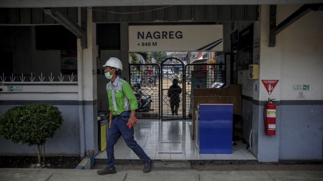 Petugas melintas di pintu masuk Stasiun Nagreg, Kabupaten Bandung, Jawa Barat, Senin (27/12/2021). [ANTARA FOTO/Raisan Al Farisi]