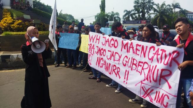  Aksi puluhan mahasiswa yang tergabung dalam Ikatan Mahasiwa Cilegon (IMC) di Landmark Cilegon, Selasa (28/12/2021). [Suara.com/ Firasat Nikmatullah]