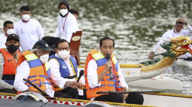 Presiden Joko Widodo (kanan) didampingi Menteri Pekerjaan Umum dan Perumahan Rakyat Basuki Hadimuljono (ketiga kanan) dan Sekretaris Kabinet Pramono Anung (kedua kanan) naik perahu naga saat meresmikan Bendungan Ladongi di Kabupaten Kolaka Timur, Provinsi Sulawesi Tenggara, Selasa (28/12/2021). [ANTARA FOTO/Jojon]