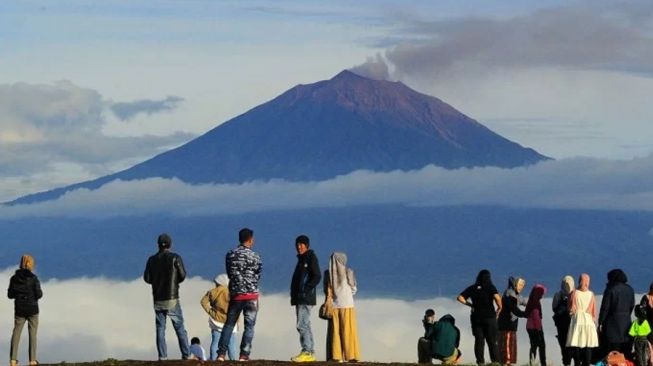 Pengunjung berada di tempat wisata Bukit Tirai Embun dengan latar Gunung Kerinci, Jambi. [Dok.Antara]