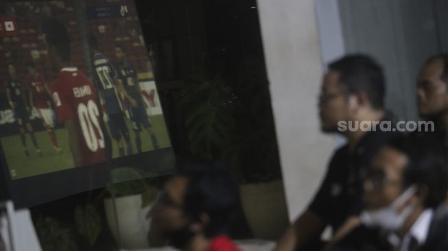 Sejumlah warga menonton laga final leg pertama Piala Asean Football Federation (AFF) Championship antara Indonesia melawan Thailand di Jalan Kemang Raya, Jakarta, Rabu (29/12/2021) malam. [Suara.com/Angga Budhiyanto]