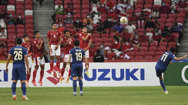 Pemain Thailand Bordin Phala (kanan) melakukan tendangan bebas pada pertandingan leg pertama final sepak bola Piala AFF Suzuki 2020 antara Indonesia dan Thailand di Stadion Nasional Singapura, Rabu (29/12/2021). [ROSLAN RAHMAN / AFP]