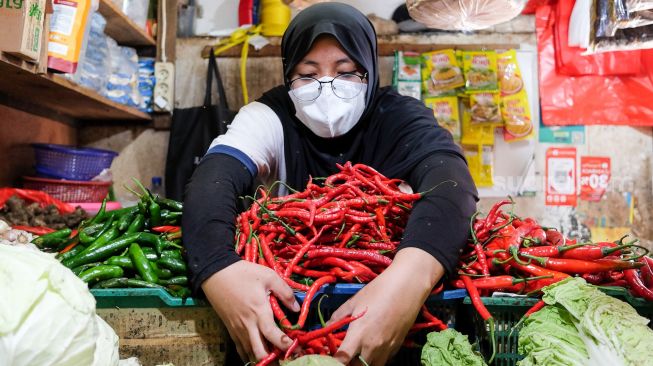 Pedagang memilah cabai untuk dijual di Pasar Tebet, Jakarta Selatan, Rabu (29/12/2021). [Suara.com/Alfian Winanto]