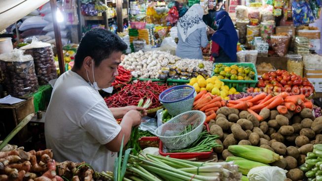 Pedagang berjualan di Pasar Tebet, Jakarta Selatan, Rabu (29/12/2021). [Suara.com/Alfian Winanto]