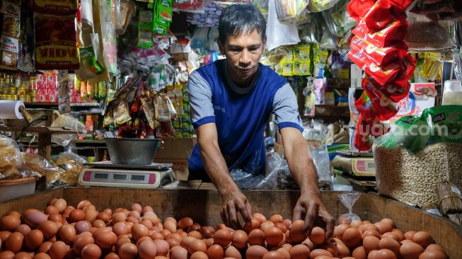 Pedagang merapikan telur untuk dijual di Pasar Tebet, Jakarta Selatan, Rabu (29/12/2021). [Suara.com/Alfian Winanto]