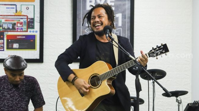 Aksi panggung Band Coconut Treez saat tampil di kantor redaksi Suara.com di Kuningan, Jakarta Selatan, Kamis (30/12/2021). [Suara.com/Alfian Winanto]