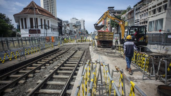 Pekerja melakukan penggalian di dekat jalur rel kereta trem yang ditemukan di lokasi pembangunan MRT Jakarta fase 2A paket kontrak atau CP 203 Glodok-Kota, Jakarta, Rabu (29/12/2021). [ANTARA FOTO/Aprillio Akbar]