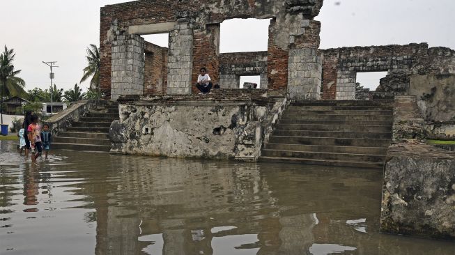 Sejumlah anak bermain di area cagar budaya Keraton Kaibon yang terendam banjir di Kasemen, Serang, Banten, Kamis (30/12/2021). [ANTARA FOTO/Asep Fathulrahman]