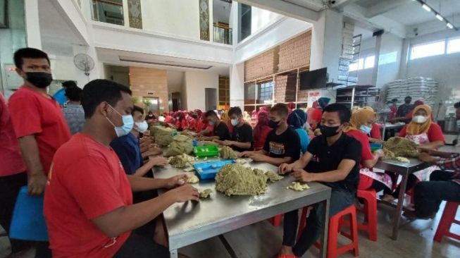 Sejumlah pekerja Bakpia 25 sedang membuat adonan bakpia di dapur. (SuaraJogja.id/Rahmat Jiwandono) 