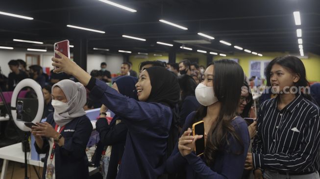 Sejumlah karyawan dan tim redaksi Suara.com menyaksikan penampilan Coconut Treez Band saat acara Syukuran Tahunan Suara.com di Kantor Redaksi Suara.com, Kuningan, Jakarta, Kamis (30/12/2021). [Suara.com/Angga Budhiyanto] 