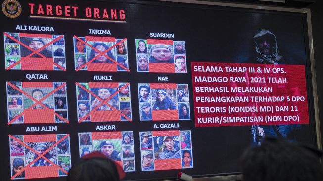 Sejumlah wartawan memperhatikan daftar pencarian orang (DPO) teroris Poso yang ditampilkan di layar pada konferensi pers akhir tahun di Mapolda Sulteng, Jumat (31/12/2021).  ANTARA FOTO/Basri Marzuki