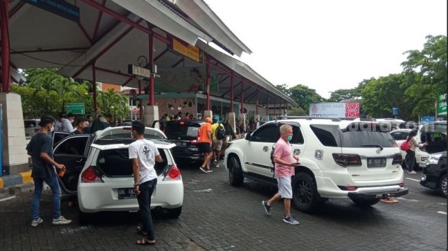 Geliat wisatawan di Bandara I Gusti Ngurah Rai, Bali pada lubur Natal dan Tahun Baru, Jumat (31/12/2021). [Suara.com/ Imam Rosidin] 