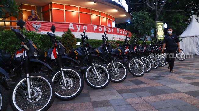 Kendaraan motor disiagakan di kawasan Bundaran HI, Jakarta Pusat, Jumat (31/12/2021). [Suara.com/Alfian Winanto]