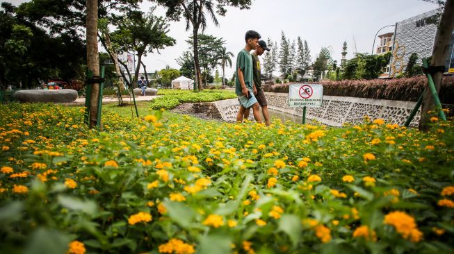 Warga melintas di Taman Bio Trans, Cempaka Putih, Jakarta, Kamis (30/12/2021). ANTARA FOTO/Rivan Awal Lingga
