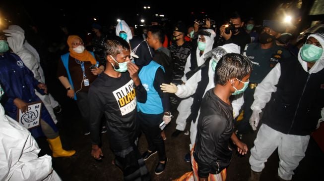 Petugas memeriksa suhu tubuh para pengungsi etnis Rohingya saat proses evakuasi oleh TNI AL di Pelabuhan ASEAN, Krueng Geukuh, Aceh Utara, Aceh, Jumat (31/12/2021).  ANTARA FOTO/Rahmad
