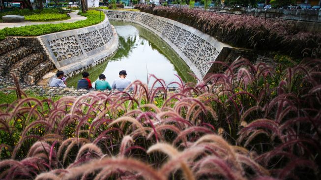 Warga bersantai di Taman Bio Trans, Cempaka Putih, Jakarta, Kamis (30/12/2021).  ANTARA FOTO/Rivan Awal Lingga
