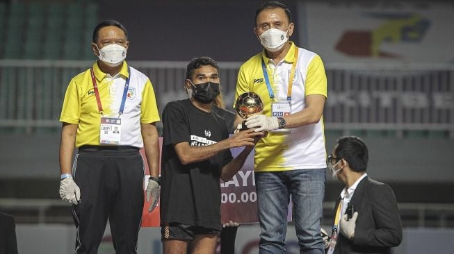 Ketua Umum PSSI Mochamad Iriawan (kanan) menyerahkan trofi pemain terbaik kepada pesepak bola Rans Cilegon Rifal Lastori (tengah) disaksikan Menpora Zainudin Amali (kiri) usai laga final Liga 2 di Stadion Pakansari, Cibinong, Kabupaten Bogor, Jawa Barat, Kamis (30/12/2021). Persis Solo keluar sebagai juara Liga 2 setelah mengalahkan Rans Cilegon FC dengan skor 2-1. ANTARA FOTO/Dhemas Reviyanto/YU