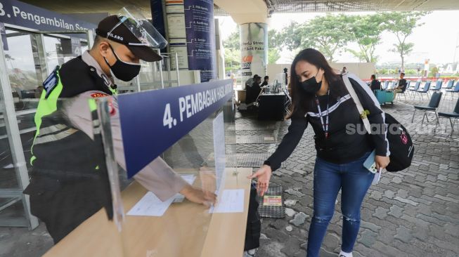 Penumpang mengambil hasil Rapid Tes Antigen di Stasiun Gambir, Jakarta Pusat, Sabtu (1/1/2022). [Suara.com/Alfian Winanto]