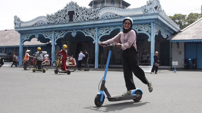 Wisatawan memakai skuter listik atau otopet untuk berkeliling di kawasan Keraton Surakarta Hadiningrat Solo, Jawa Tengah, Sabtu (1/1/2022). ANTARAFOTO/Maulana Surya
