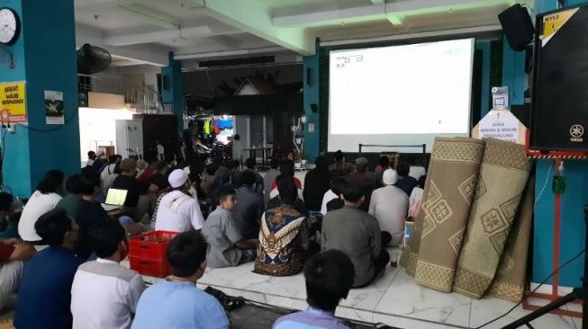 Sejumlah warga Jogja menyaksikan pertandingan Final Leg 2 Piala AFF 2020 di Masjid Jogokariyan, Kemantren Mantrijeron, Kota Jogja, Sabtu (1/1/2022). [Muhammad Ilham Baktora / SuaraJogja.id]